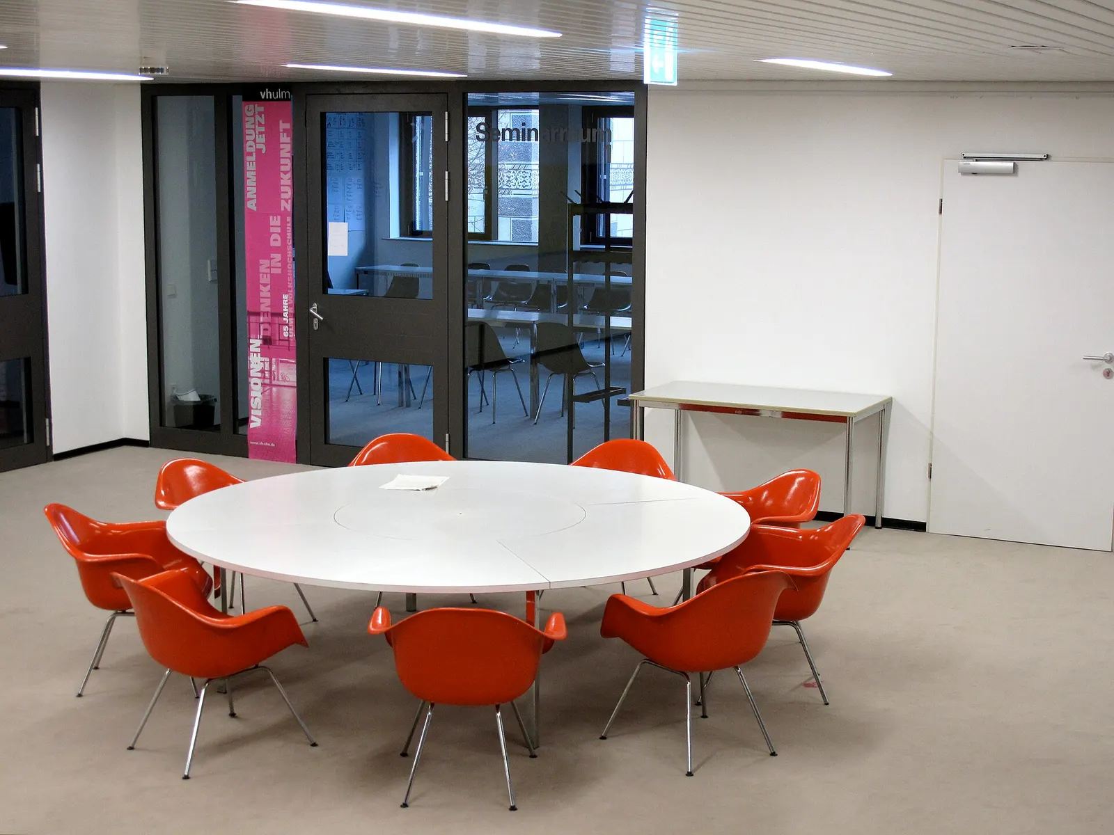 Foyer of the EinsteinHaus (1st floor) of the Ulmer Volkshochschule (vh Ulm) with the orange "Dinging Armchairs" of Charles and Ray Eames.